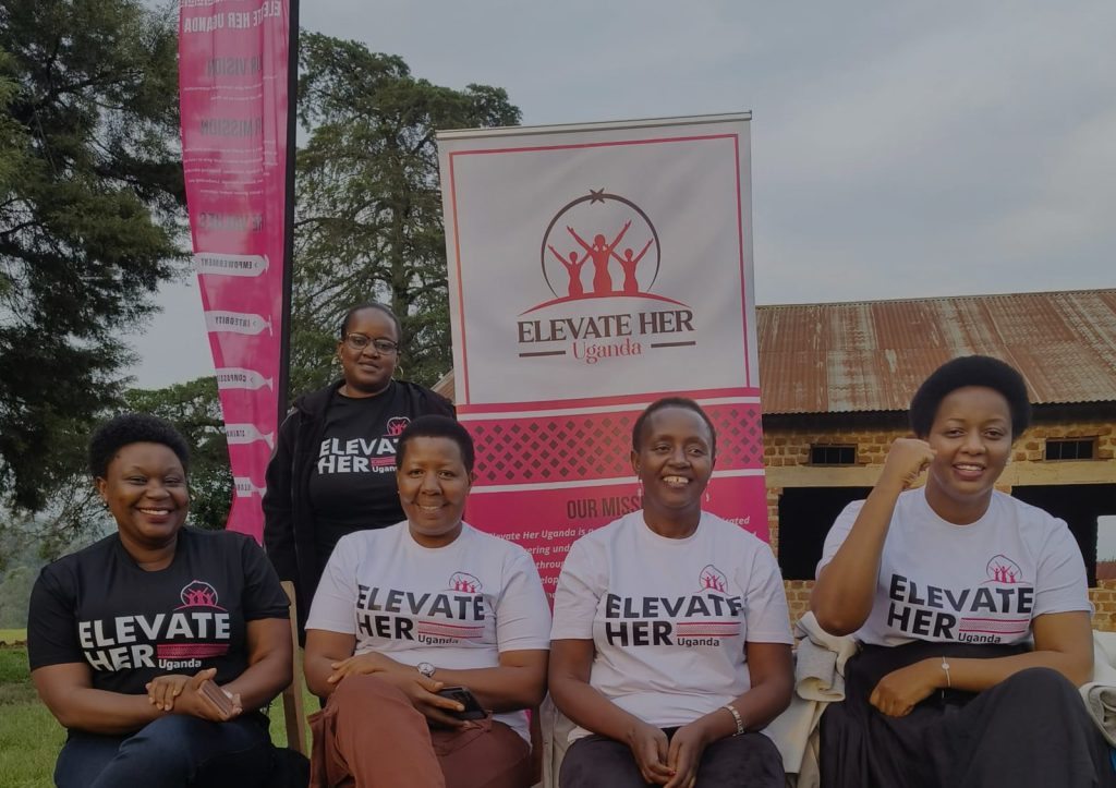 The Elevate Her team seated in front of their banner