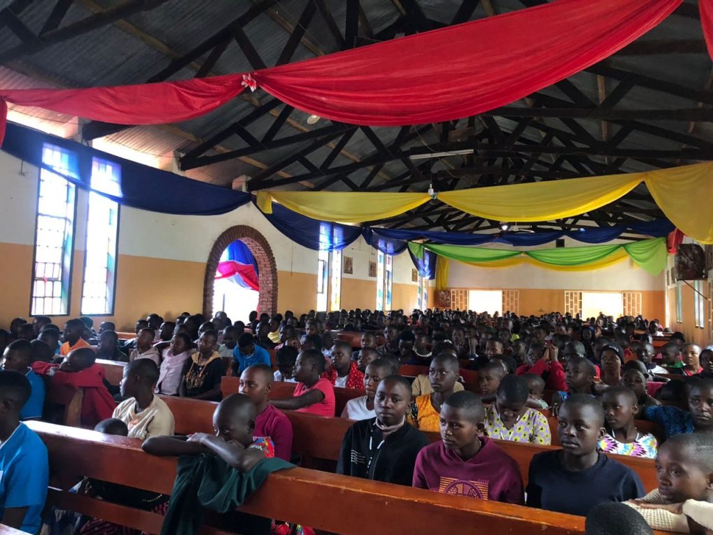 Women and girls fill the pews at a community rally in a church
