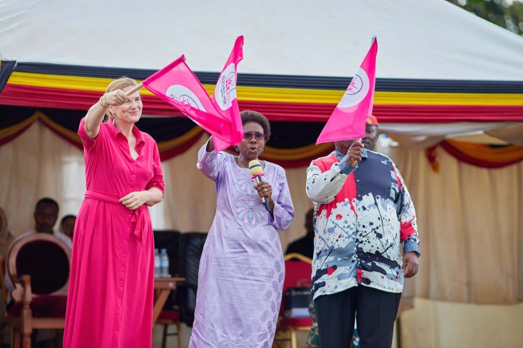 Guests wave Elevate Her flags on stage