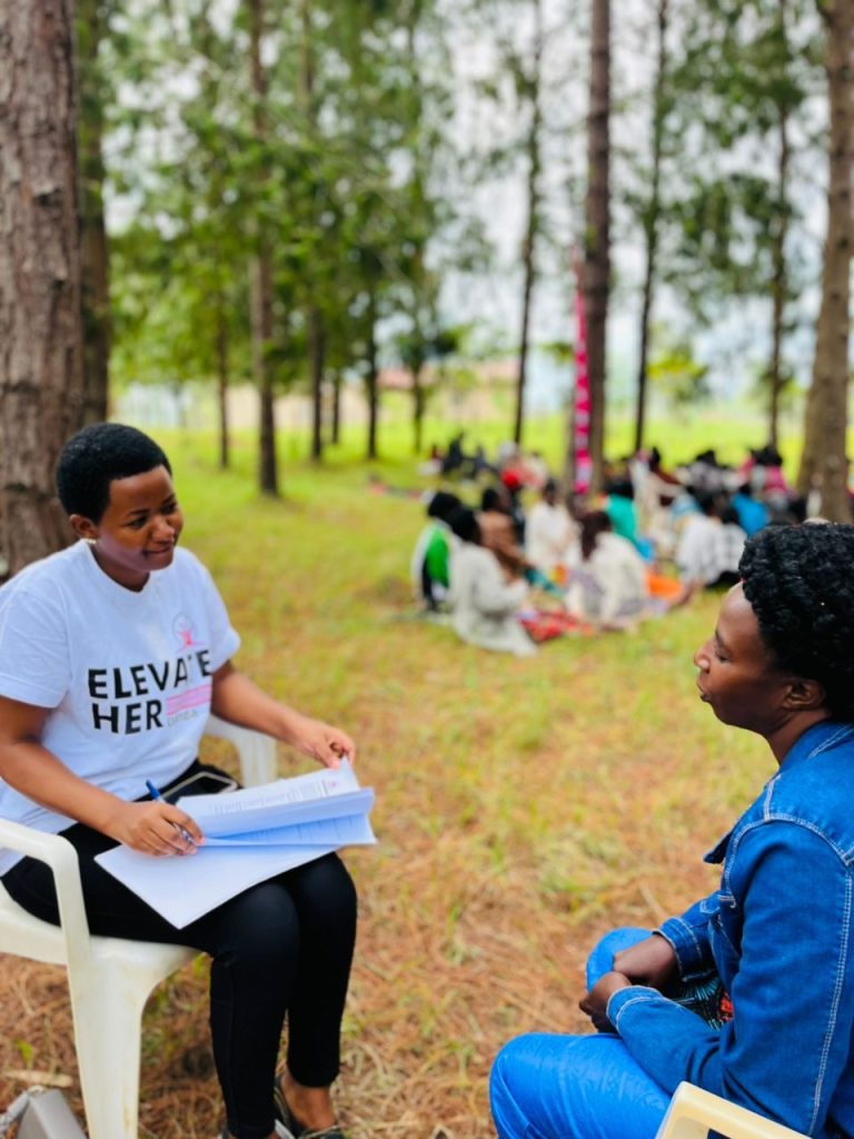 A trainer talks with a woman in a pine forest