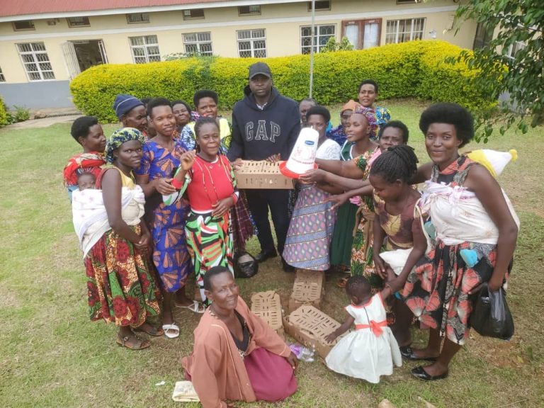 Women in Ruhinda receive poultry equipment on a school field