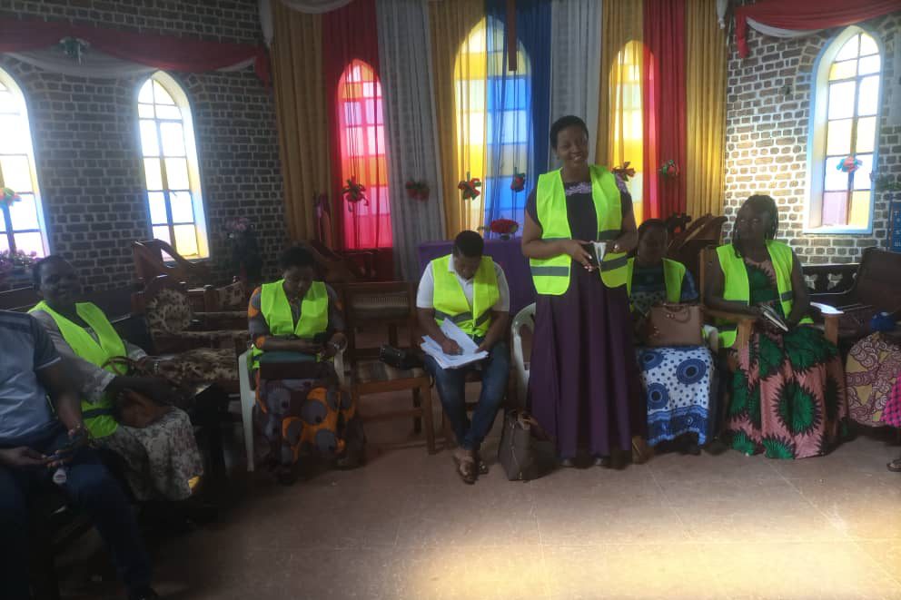 Women in high-visibility vests at a training session in a church